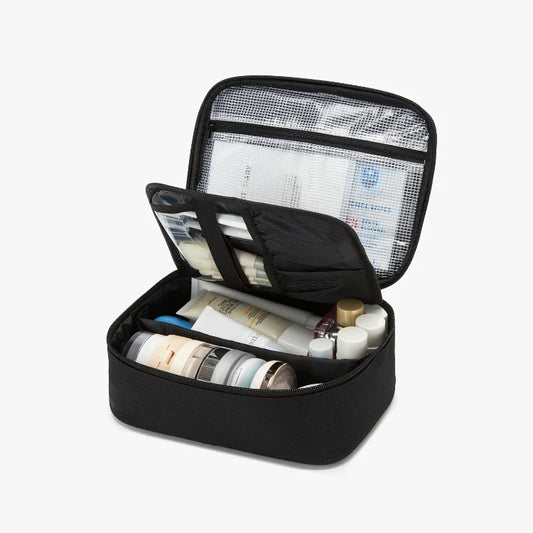 Black travel makeup organizer with skincare products on a white background