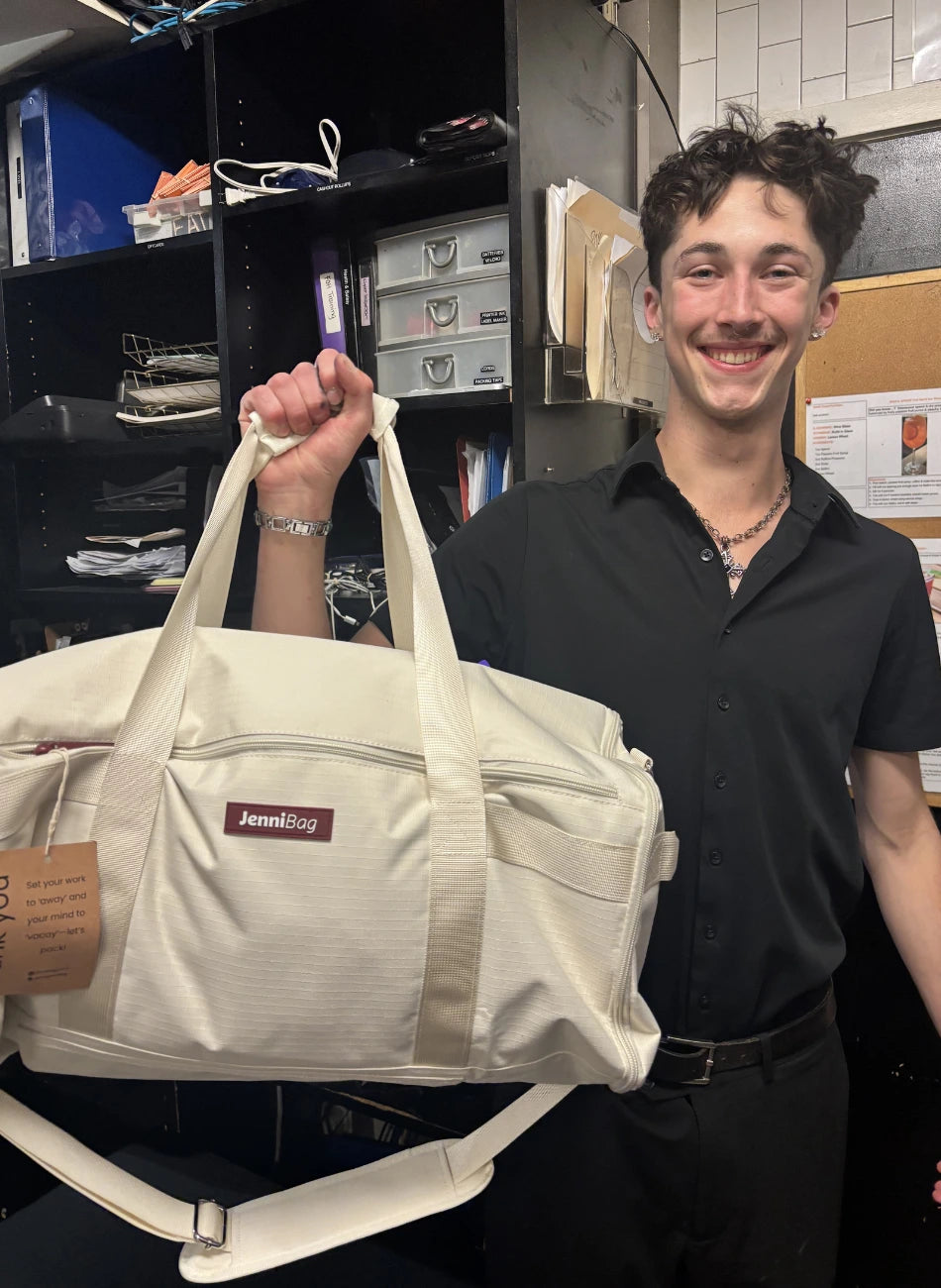 Person holding a white bag with a visible brand logo in an indoor setting