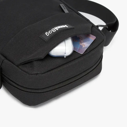 Black travel bag with compartments open, showing organized storage.