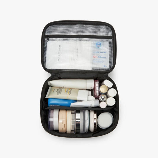 Open black travel case with skincare products on a white background