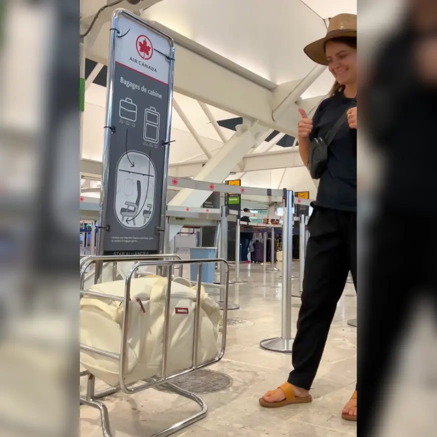 Person standing in an airport with a sign indicating luggage rules.
