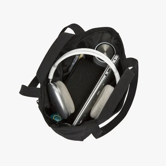 Black backpack with a smartphone and headphones inside on a white background