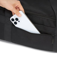 Person placing a white smartphone into a black pocket.