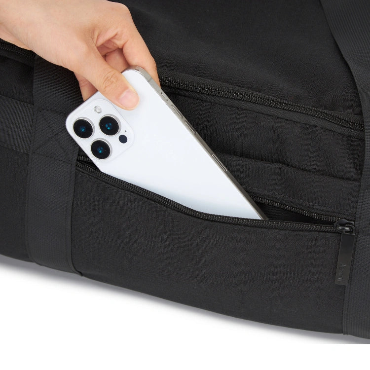 Person placing a white smartphone into a black pocket.