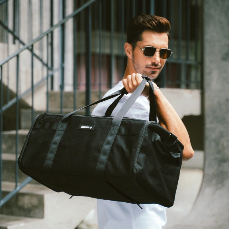 Man holding a black duffel bag in an urban setting