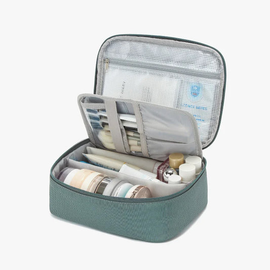 Open travel makeup case with various products on a light background