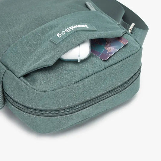 Green travel bag with a shoe and a card inside, on a white background.
