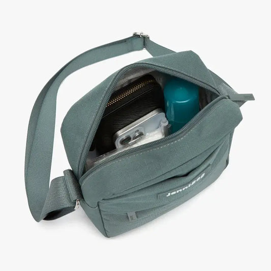 Green shoulder bag with contents on a white background