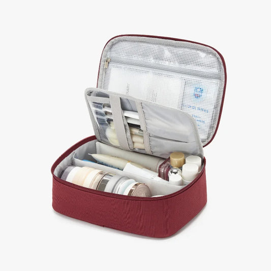 Open red cosmetic case with toiletries on a white background