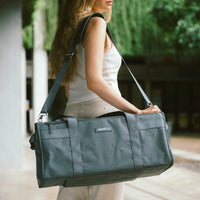 Woman carrying a dark blue bag outdoors