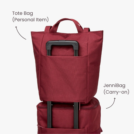 Stack of two red bags with labels: one tote bag and one carry-on bag.