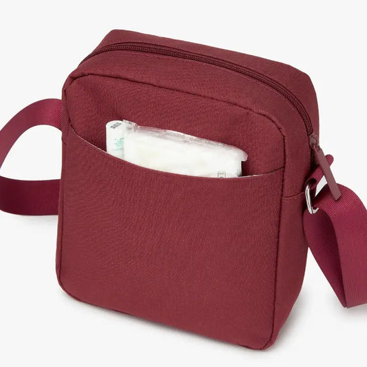 Maroon shoulder bag with a pocket open on a white background.