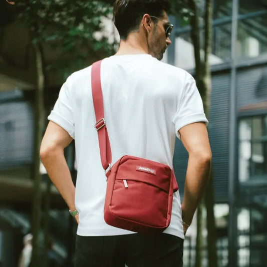 Person wearing a red shoulder bag in an urban setting
