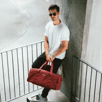 Man holding a red bag in an urban setting