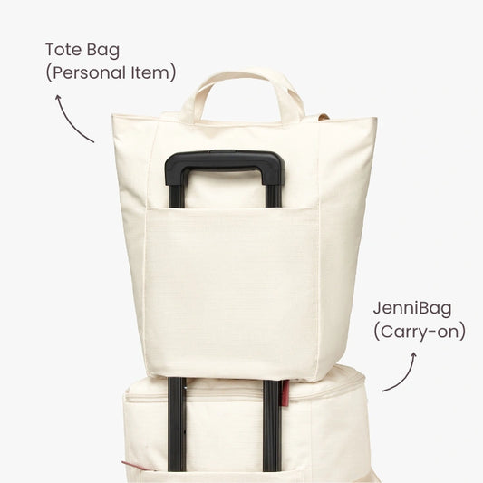 Stack of two tote bags with labels on a plain background