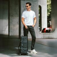 Man pulling a black suitcase in an urban setting