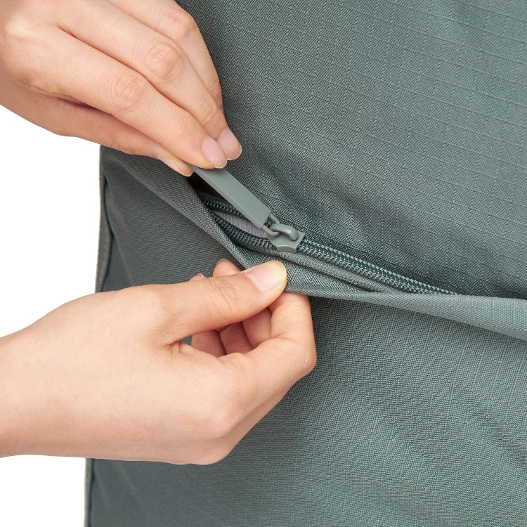 Close-up of hands zipping a green garment.