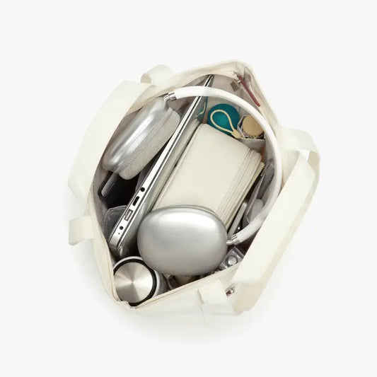 White handbag with silver and gold accessories on a white background