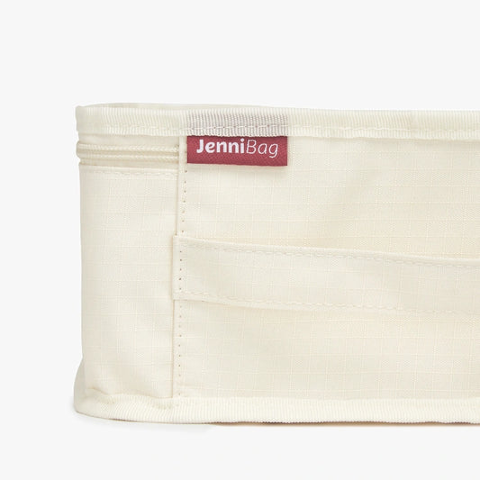 Beige fabric bag with a red label on a white background