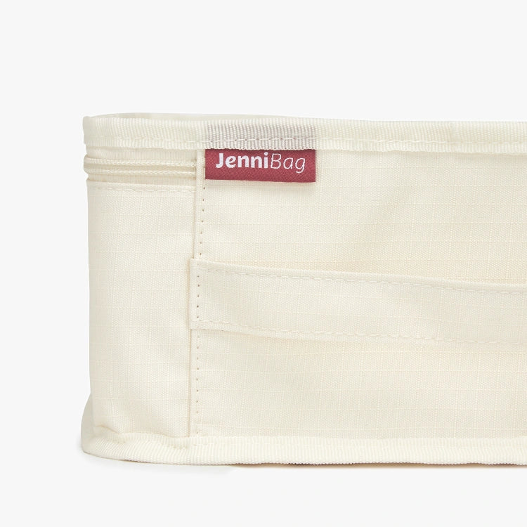 Beige fabric bag with a red label on a white background