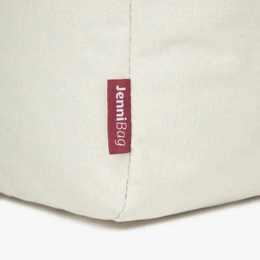 Close-up of a beige bag with a red label.