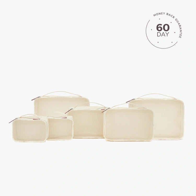 A set of beige packing cubes of various sizes with a white cube labeled '60 DAY'.