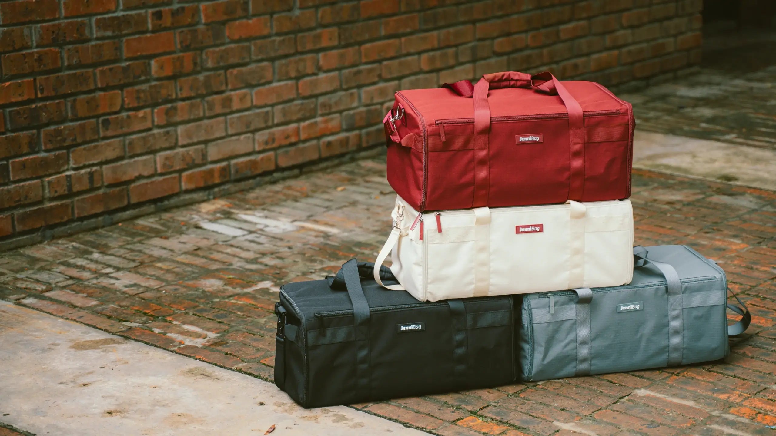 Stack of three bags against a brick wall.