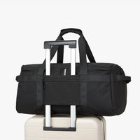 Black duffel bag with wheels on a white background