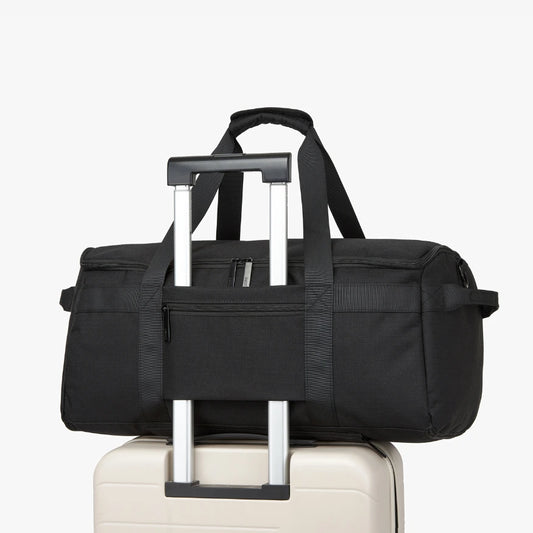 Black duffel bag with wheels on a white background