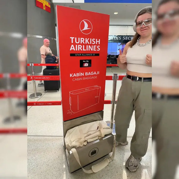 Traveler beside a Turkish Airlines cabin-baggage sizer with a cream JenniBag inside