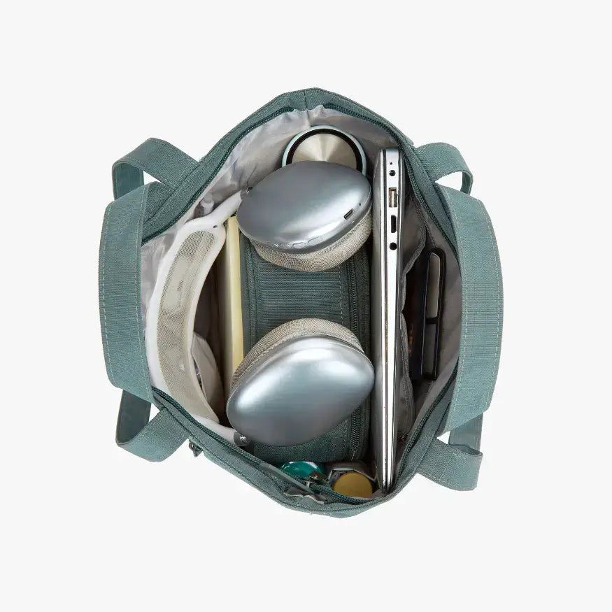 Green bag with electronic devices inside on a white background