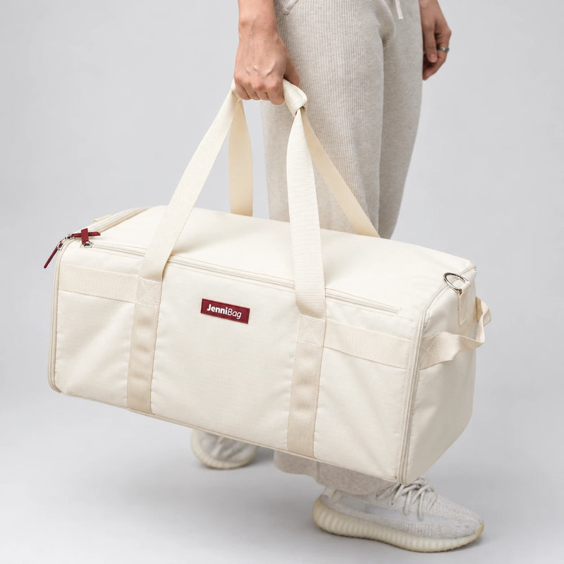 Woman carrying JenniBag Classic by its handles on a cobblestone street