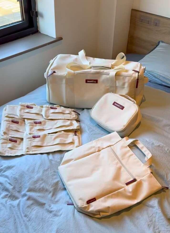 JenniBag with matching pouches laid out on a bed